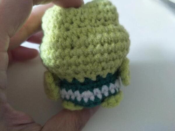 sew arms on the body for crochet frog pattern