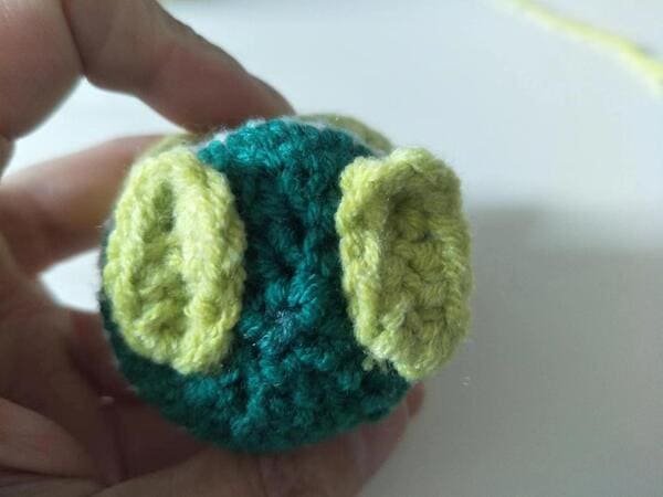 sew feet on the body for crochet frog pattern