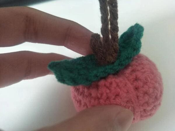 sew the leaf and stem on the body of peach