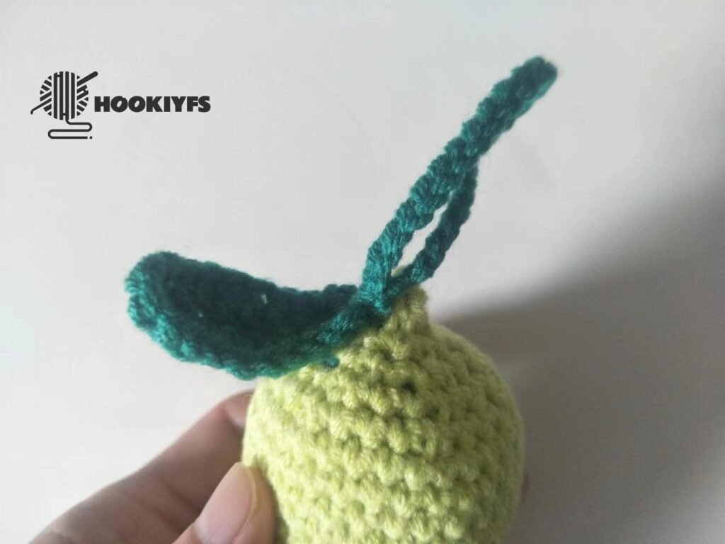 sewing the leaf on the body of lemon crochet pattern.jpg
