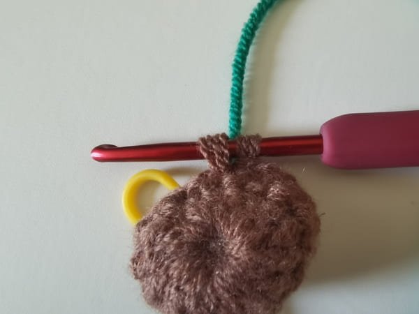 put dark green yarn behind two brown loops for sock crochet