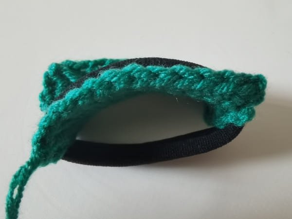 put the black hair rope on the dark green fabric