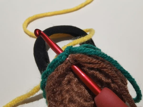put the yellow yarn behind two fabrics