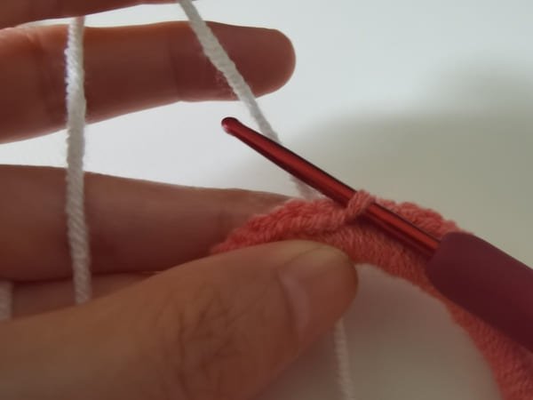 rice white yarn behind the pink fabric