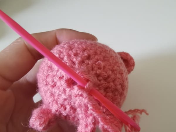 use yarn needle to pick back loop to tighten the opening for crochet pig